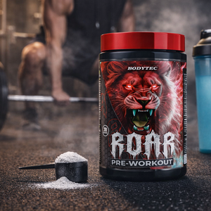 Bodytec Roar pre-workout supplement container with a shaker and scoop on a gym floor.
